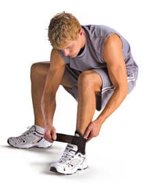 A man putting on an ankle brace