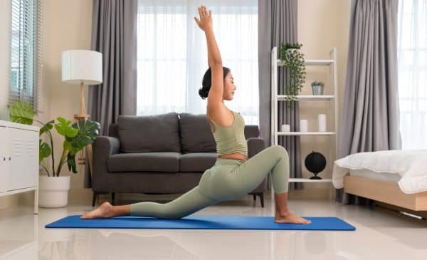 Woman performing yoga on an exercise mat in living room