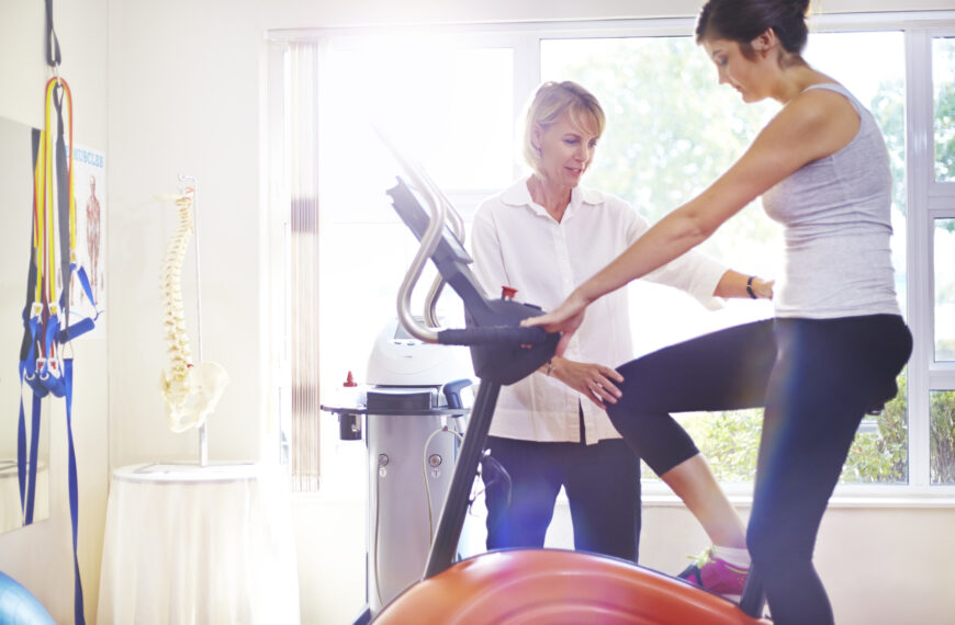 Physical therapist guiding patient on stationary bike